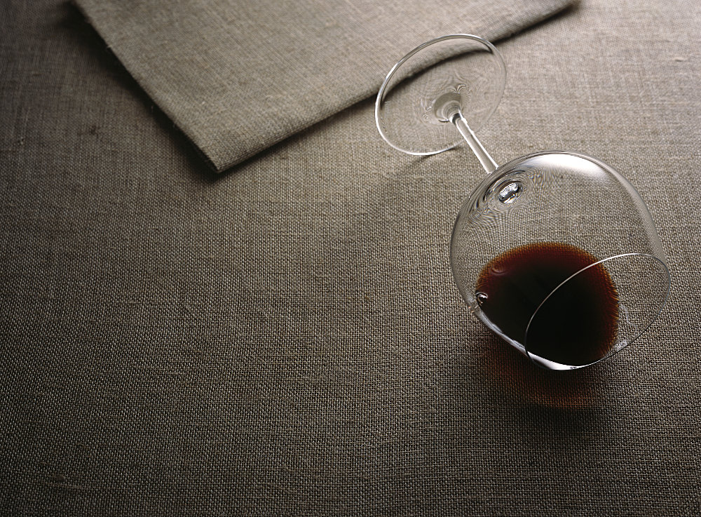 Glass of red wine on its side – Photograph by George Ong